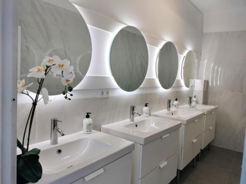 a bathroom with three sinks and two mirrors at Room27- city center in La Laguna