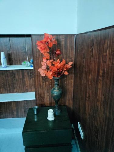 a vase with orange flowers in it on a table at WZ-294 G block, Hari nagar,Jail road,near OM sweets or behind fitness factory gym in New Delhi
