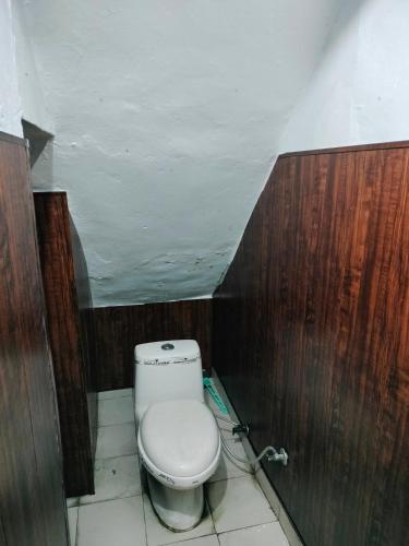 a bathroom with a toilet in a wooden wall at WZ-294 G block, Hari nagar,Jail road,near OM sweets or behind fitness factory gym in New Delhi
