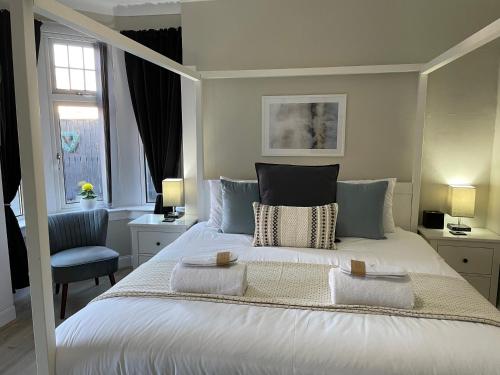 sypialnia z białym łóżkiem i 2 ręcznikami w obiekcie Peacock Guest House w mieście Largs