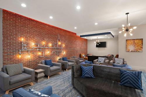 a waiting room with couches and a brick wall at Four Points by Sheraton Plano in Plano