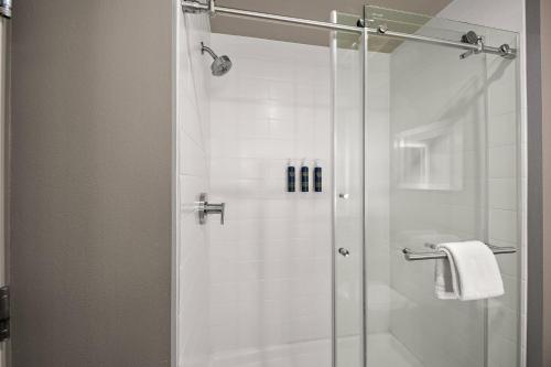 a shower with a glass door in a bathroom at Four Points by Sheraton Plano in Plano