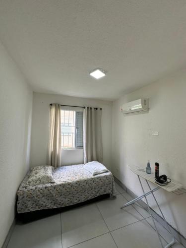 a small bedroom with a bed and a window at Apartamento inteiro Varzea Grande MT in Várzea Grande