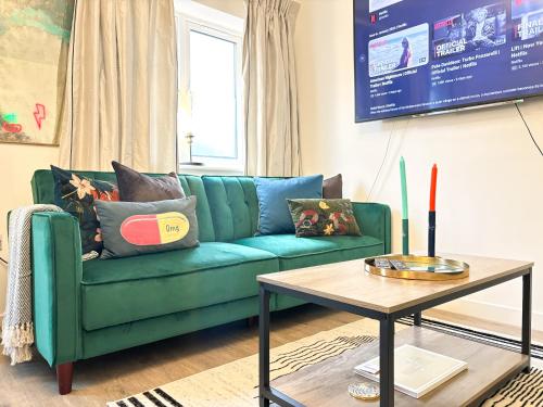 a living room with a green couch and a table at Luxury London Two Bedroom Apartment in West Dulwich