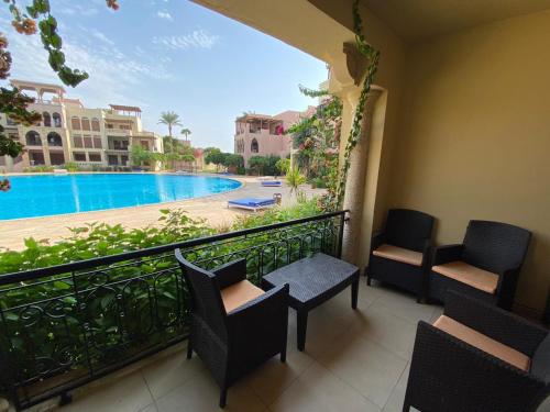 a balcony with chairs and a view of a pool at one bedroom apartments aqaba on 2 swimming pool Tala bay in Aqaba