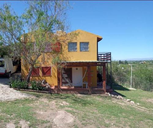ein kleines gelbes Haus auf einem Feld in der Unterkunft Casa en Balcón de Mallín, Mirador del Lago in Bialet Massé