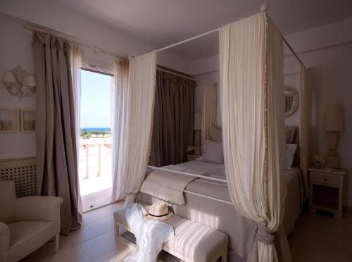 a bedroom with a bed and a large window at Borgo Egnazia in Savelletri di Fasano