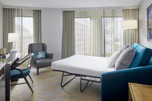 a hotel room with a bed and a couch and chairs at Grand Bohemian Orlando, Autograph Collection in Orlando