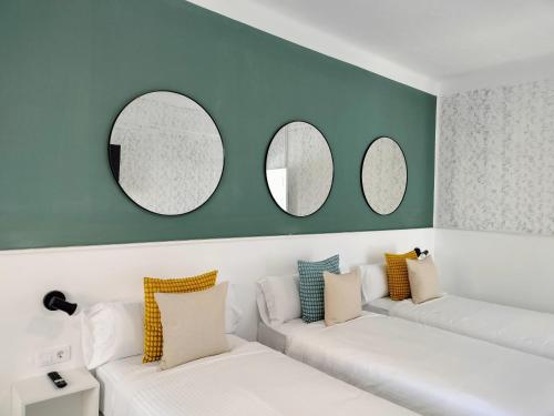 a living room with white couches and three mirrors at Room27 in La Laguna