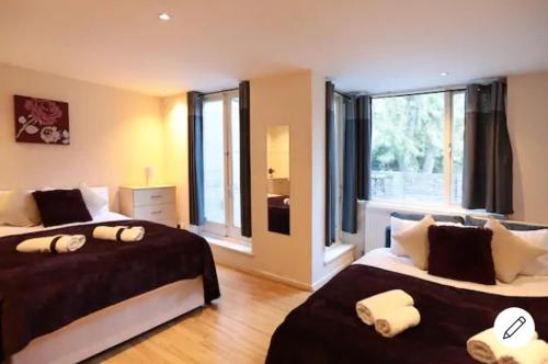 1 dormitorio con 2 camas y ventana grande en Comfy Bedrooms near Euston Station - 1 Exmouth, en Londres