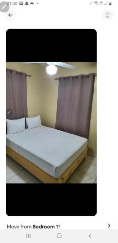 聖斐利－銀港的住宿－July，一间卧室配有一张带白色床单和窗帘的床