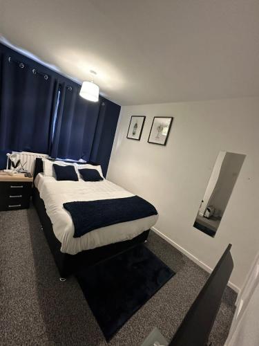 a bedroom with a large bed with blue curtains at One room only Bathroom and toilet shared Located in the city in Newcastle upon Tyne