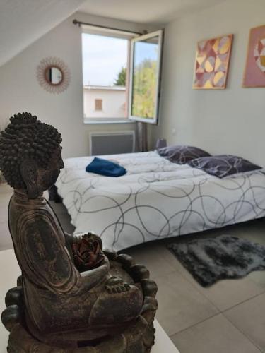 a bedroom with a bed and a statue in the foreground at Charmant appart près Europa-Park Rulantica 30 min in Erstein