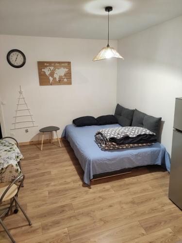 um quarto com uma cama, uma cadeira e um relógio em Charmant appartement à 25 minutes de Paris. em Argenteuil