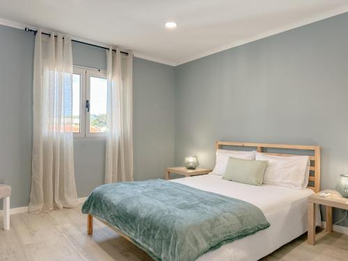 ein weißes Schlafzimmer mit einem Bett und einem Fenster in der Unterkunft South Shore 2 - HOST & CHILL in São Roque