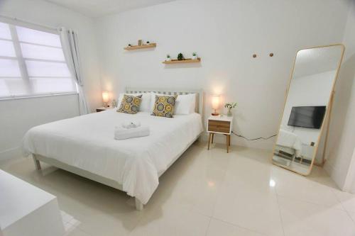 1 dormitorio blanco con 1 cama grande y espejo en Modern 1 Bd Room 1 block from the Beach, en Miami Beach