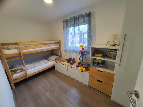 a bedroom with two bunk beds and a window at Ferienwohnung Weizblick in Weiz