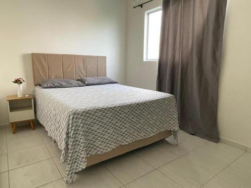 ein Schlafzimmer mit einem Bett mit einer weißen Bettdecke und einem Fenster in der Unterkunft Apartamento Indicado no Centro Petrolina in Petrolina