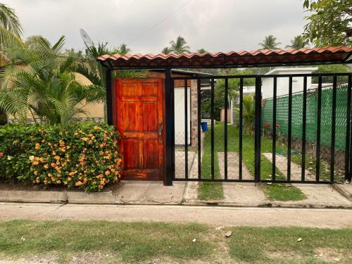 a gate with a wooden door and some flowers at Beach Lomas in La Libertad