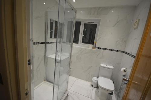 uma casa de banho branca com um chuveiro e um WC. em Small single bed em Oxford