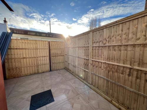 a privacy fence with the sun shining on it at Luxurious London Studios in Harrow