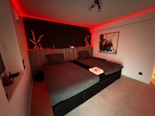 1 dormitorio con 1 cama con iluminación roja en RheinMosel Glück Wellness en Koblenz