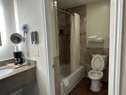 a bathroom with a toilet and a shower and a sink at Palace Inn I-45 & Bellfort in Houston