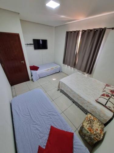 Cette chambre comprend 2 lits et une télévision. dans l'établissement Casa completa -prox Capitólio, Sto Hilário, Piment, à Pimenta