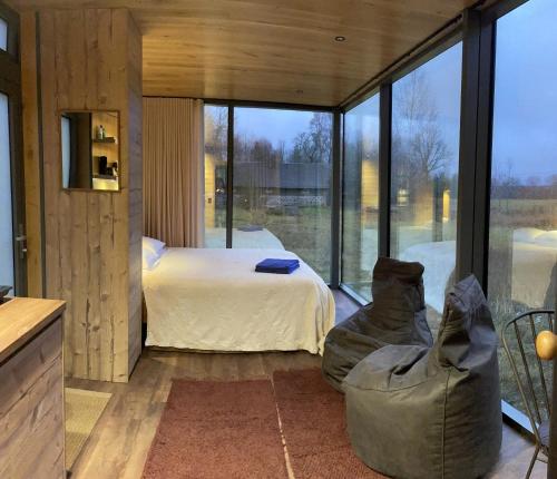 a bedroom with a bed and a large window at Kuldi Mirror House 