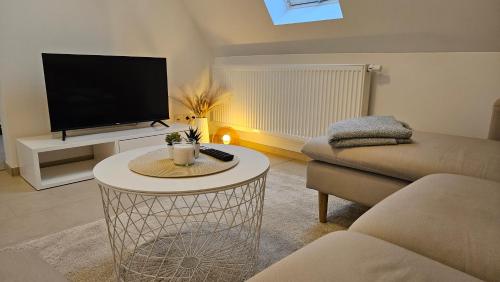 a living room with a tv and a table at FeWo AS 5 One Bamberg in Hallstadt