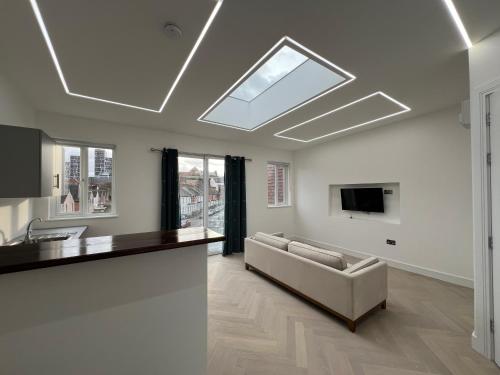 a living room with a couch and a tv on the ceiling at Luxurious London Studios in Harrow