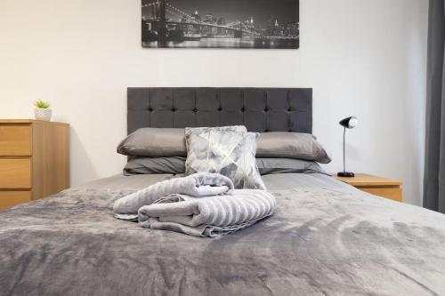 ein Bett mit zwei Handtüchern darüber in der Unterkunft Exquisite stays, modern apartment in city centre in Coventry