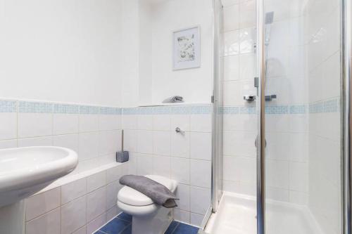 ein Bad mit einer Dusche, einem WC und einem Waschbecken in der Unterkunft Exquisite stays, modern apartment in city centre in Coventry