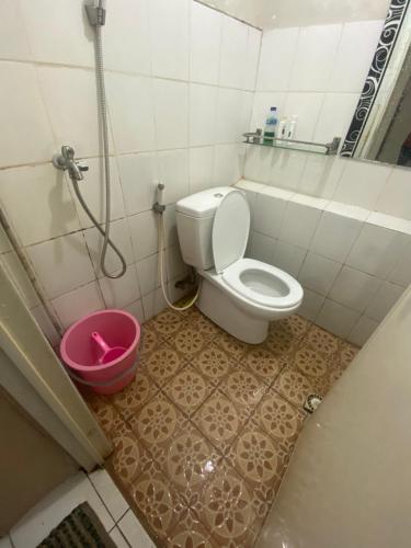 a bathroom with a toilet and a pink bucket at Alkhafy property in Jakarta