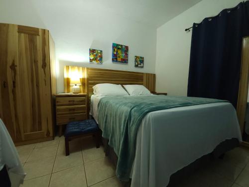ein Schlafzimmer mit einem großen Bett und einem Nachttisch sowie einem Bett mit einem sidx sidx sidx in der Unterkunft Apart Eco Estudio Joocah in Trujillo