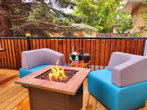 two chairs and a table with a fire pit on a deck at Welcome to Happy Place where Cozy Comfort Meets Exquisite Luxury in Edmonton