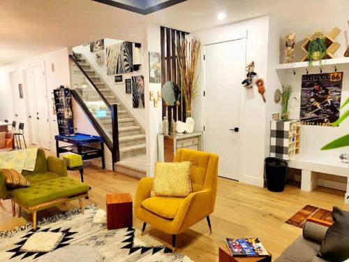- un salon avec des chaises jaunes et un escalier dans l'établissement Welcome to Happy Place where Cozy Comfort Meets Exquisite Luxury, à Edmonton
