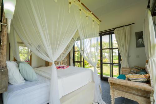 a bedroom with a bed with a canopy at Villa Labak Sari Tabanan in Antasari