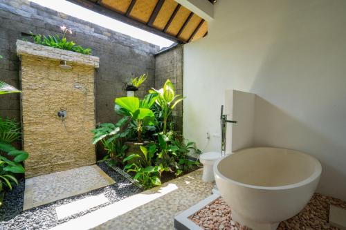 a bathroom with a toilet and a bath tub at Villa Labak Sari Tabanan in Antasari
