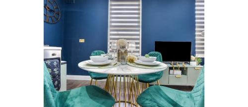 a dining room with blue walls and a table and chairs at Cozy 3 Bedroom Flat in London! in London