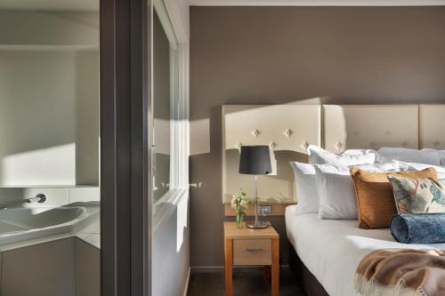 a bedroom with a white bed and a sink at Fable Christchurch in Christchurch