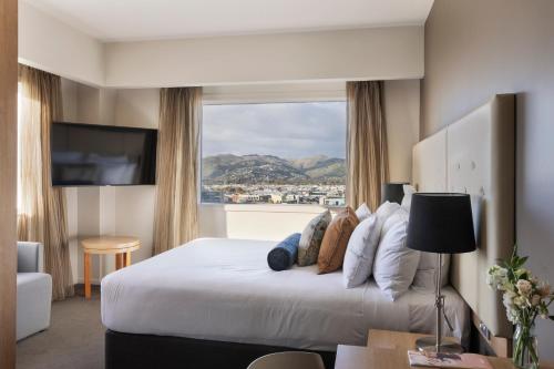 a hotel room with a large bed with a window at Fable Christchurch in Christchurch