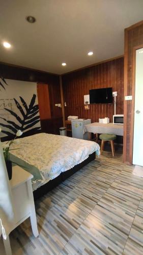 a bedroom with a large bed and a living room at บ้านสุขใจ อัมพวา in Samut Songkhram