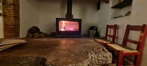 a living room with a fireplace and two chairs at Monte do Arneiro in Sousel