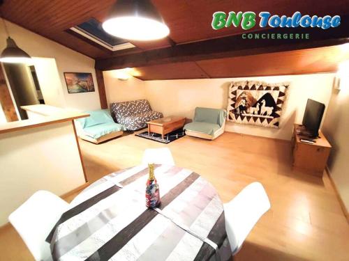 un salon avec une table et un canapé dans l'établissement ► BNB TOULOUSE ► Le Charmant Balmanais • Clim • Garage • 24/7, à Balma