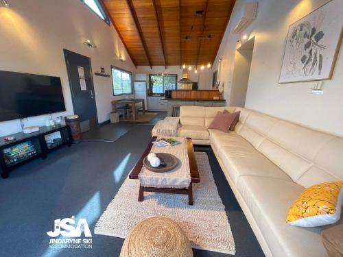 a living room with a couch and a table at Pine Peak in Jindabyne