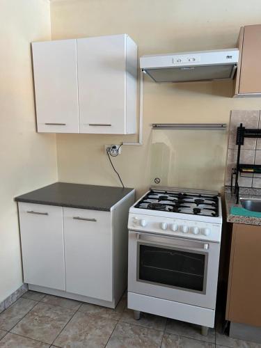 a kitchen with a stove and white cabinets at Chez Rereani in Punaauia