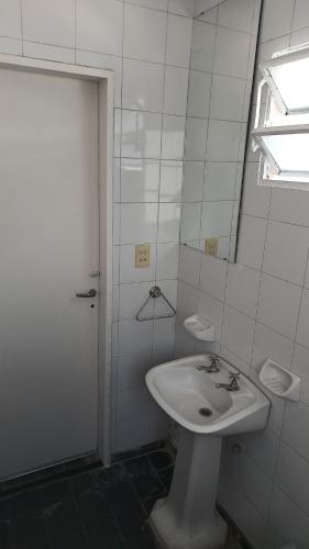 y baño blanco con lavabo y ducha. en Departamento para 2 personas en Bialet Massé