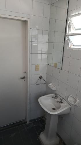 a white bathroom with a sink and a shower at Departamento para 2 personas in Bialet Massé