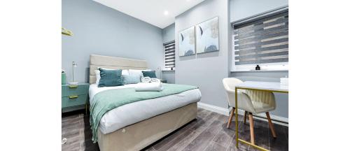 a small bedroom with a bed and a table at Sleek Modern 3BR Flat in Nunhead in London